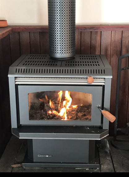 Black Burning Log Turbo 10 fireplace with a metallic finish, showcasing a realistic burning log in a wood fireplace setting.