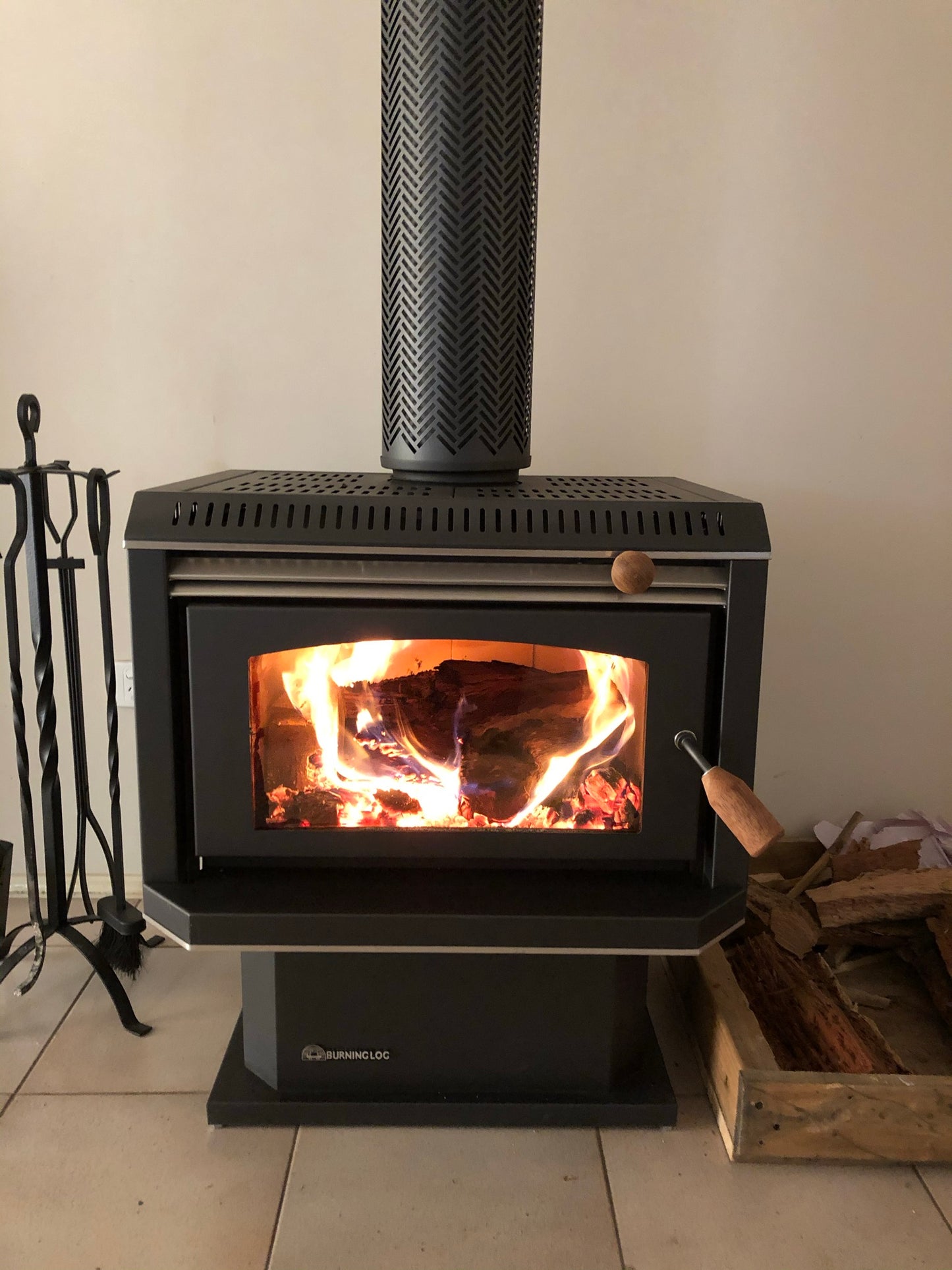 Black Burning Log Turbo 10 fireplace with metallic finish, showcasing a wood fireplace design and burning logs inside.