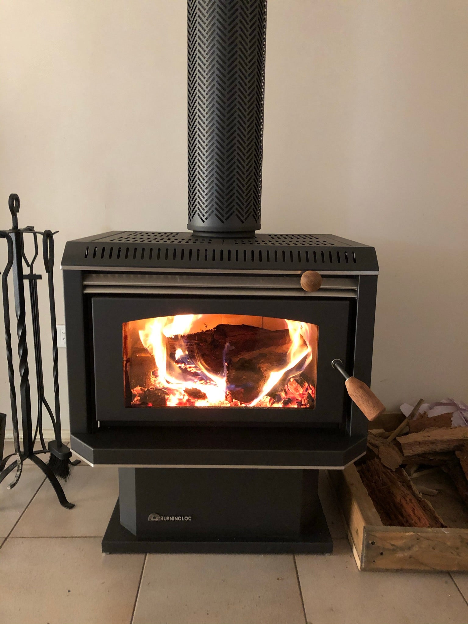 Black Burning Log Turbo 10 fireplace with metallic finish, showcasing a wood fireplace design and burning logs inside.