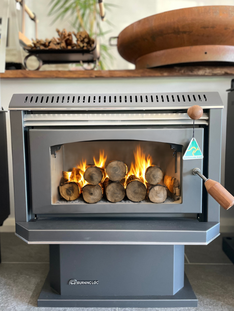 Black Burning Log Turbo 10 wood fireplace with metallic finish, showing the log inside a modern fireplace setting.