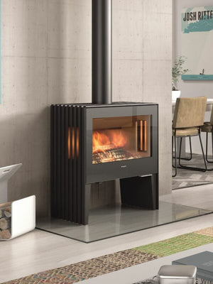 Castworks Hergóm Glance L wood fireplace with sleek black metal exterior and large glass front for viewing the fire.