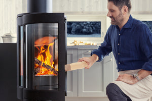 Loading firewood into a Jøtul F 370 V2 Advance wood heater
