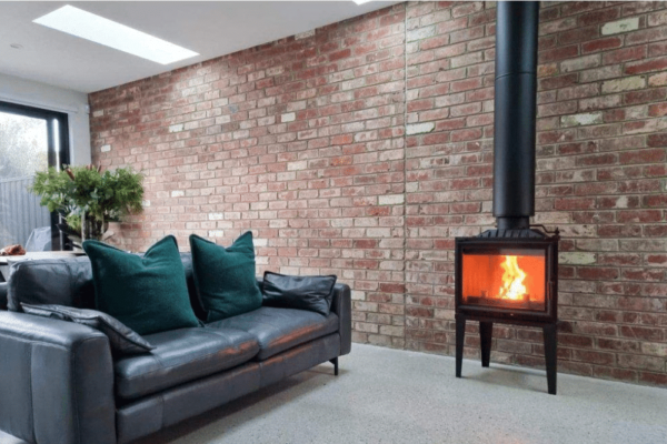Modica 600 Glass Fronted wood fireplace installed with a black flue in a modern living room