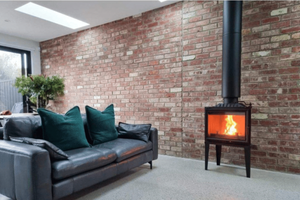 Modica 600 Glass Fronted wood fireplace installed with a black flue in a modern living room