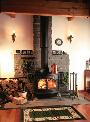 Vermont Castings Defiant black cast iron wood heater installed in a traditional living room