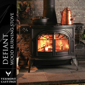 Vermont Castings Defiant cast iron wood heater burning in a traditional fireplace setting