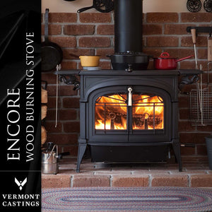 Vermont Castings Encore black cast iron wood heater installed in a brick fireplace