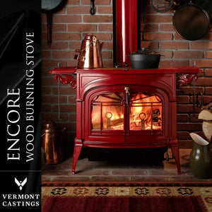 Vermont Castings Encore Bordeaux Enamel cast iron wood heater burning in a traditional fireplace setting