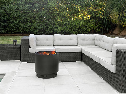 VisionLINE MK2 black outdoor fire pit in a backyard entertaining area