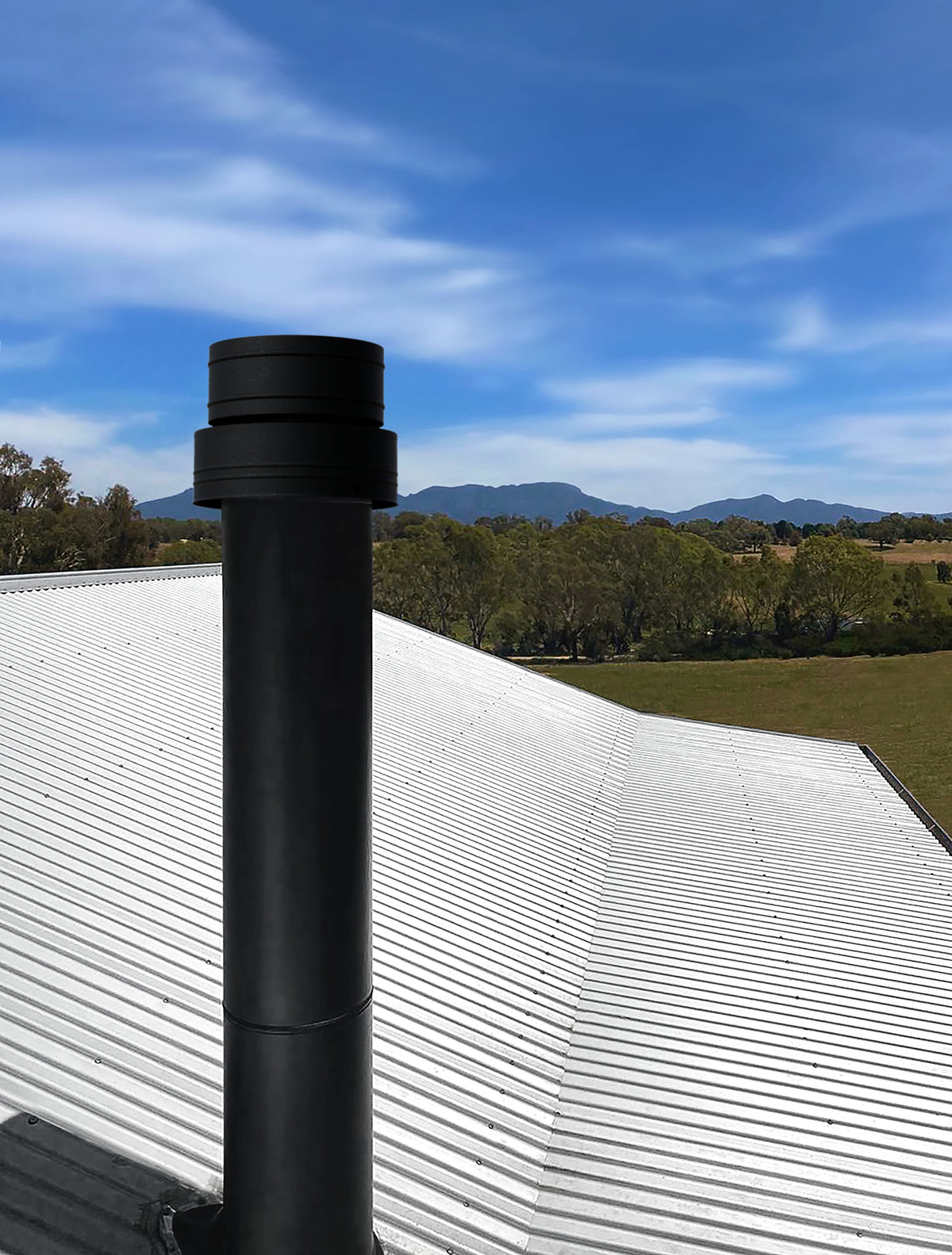 VisionLINE pellet heater flue with black roof termination installed through a metal roof